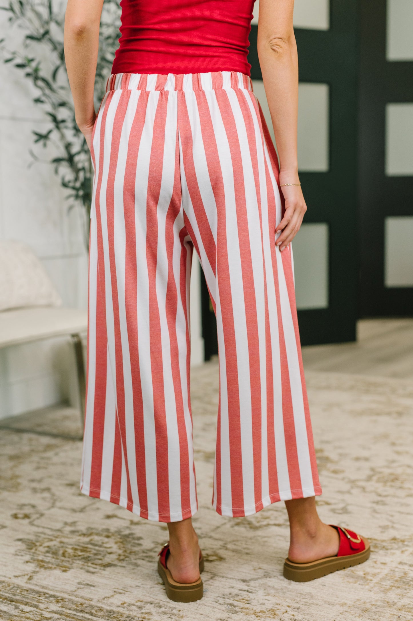 Person wearing red and white striped pants with a blurred background