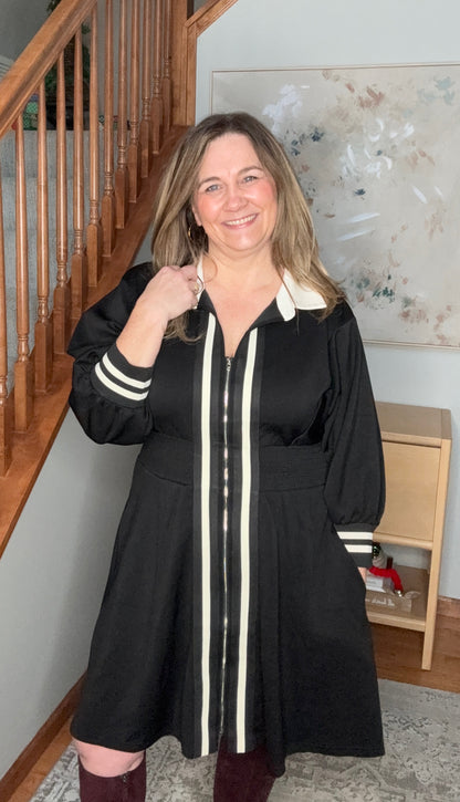 Woman wearing a black coat with white stripes indoors