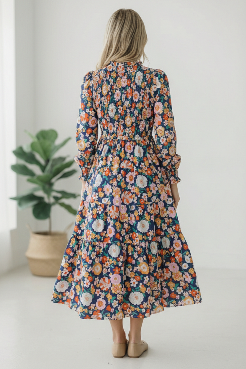 Woman wearing a floral dress standing in a room with a plant in the background