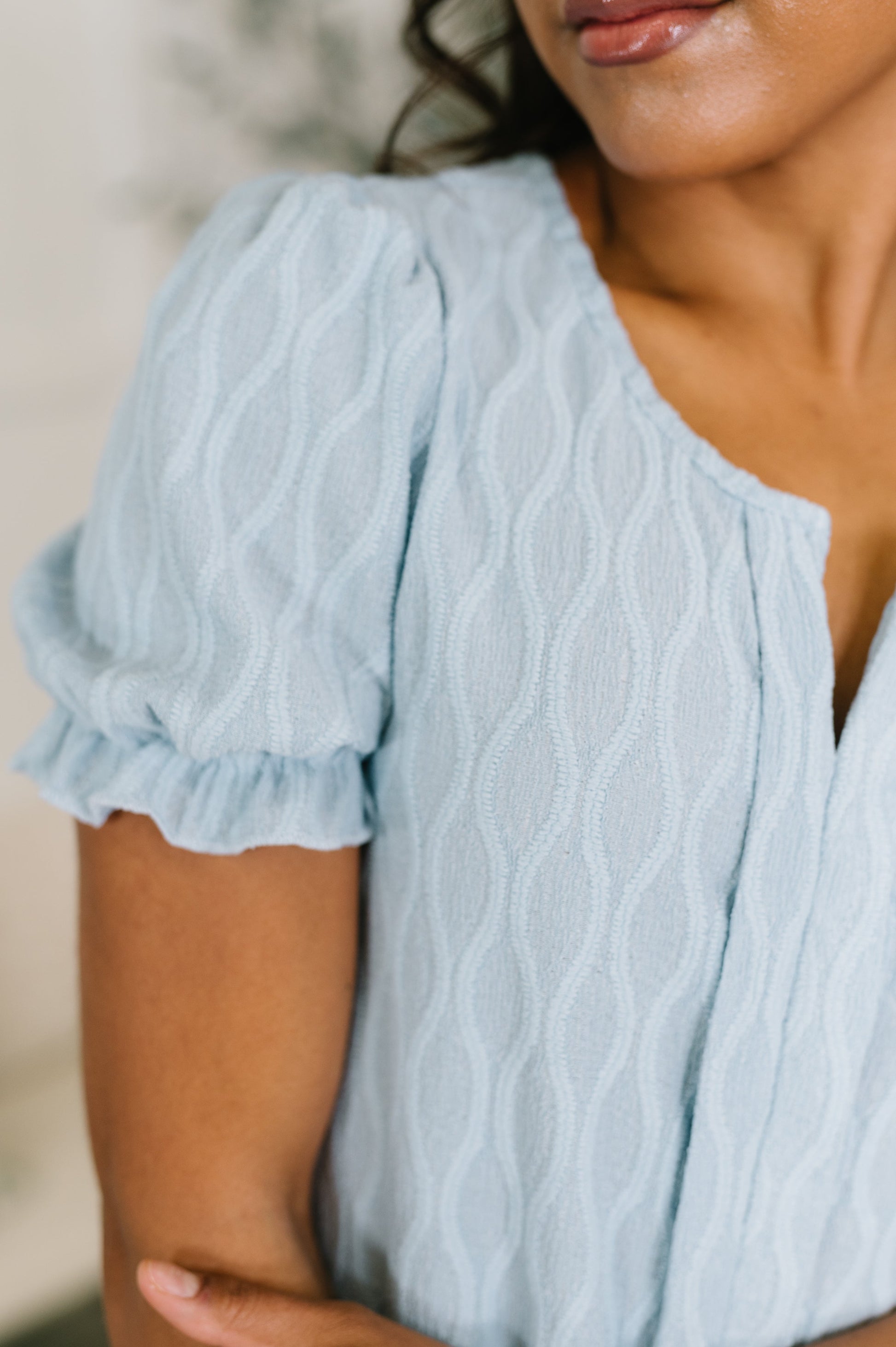 Light blue textured dress with ruffled sleeves worn by a person.