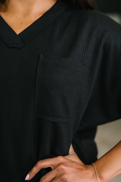 Close-up of a person wearing a black outfit with a blurred background