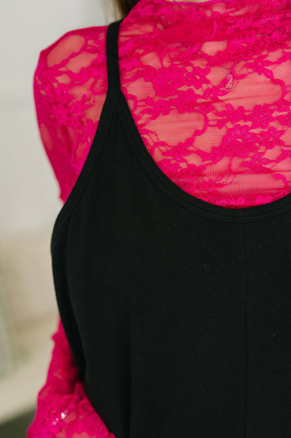 Black dress with pink lace detailing on a blurred background