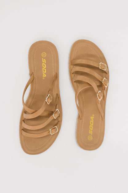 Pair of tan sandals with gold buckles on a white background
