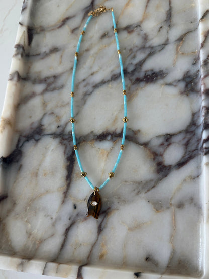 Turquoise beaded necklace on a marble surface