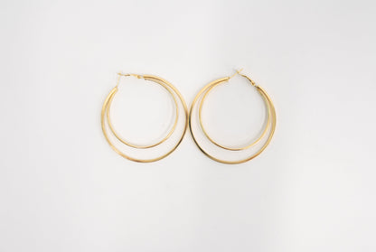 A pair of gold-toned double-hoop earrings on a clean white background.