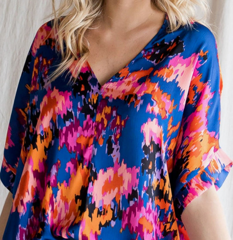 Colorful patterned top worn by a person with a neutral background