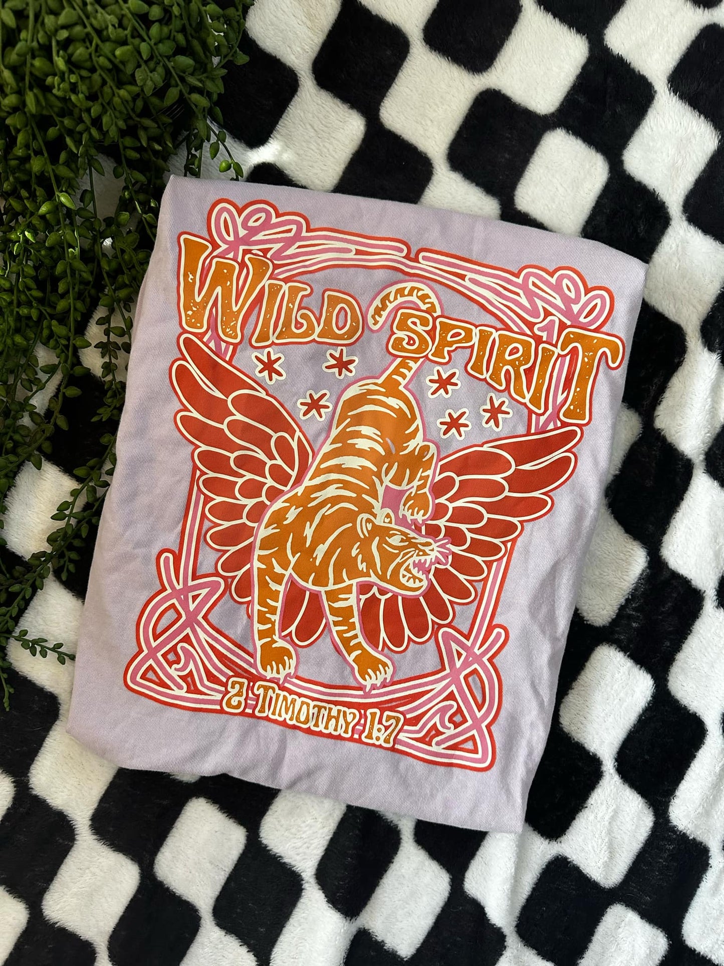 Photo of a lavender colored tee that says Wild Spirit with a tiger that has wings
