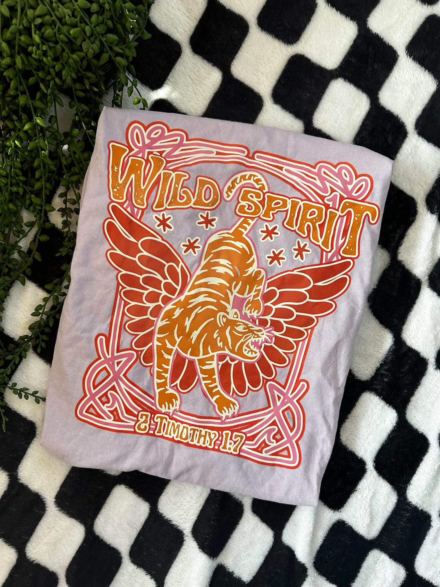 Photo of a lavender colored tee that says Wild Spirit with a tiger that has wings