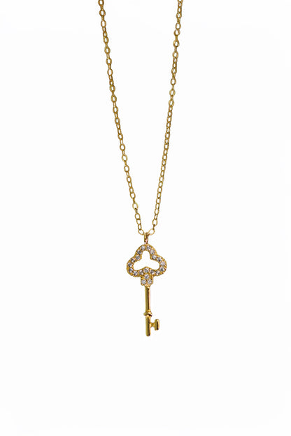Gold key-shaped pendant necklace on a white background