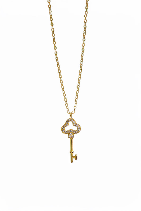 Gold key-shaped pendant necklace on a white background