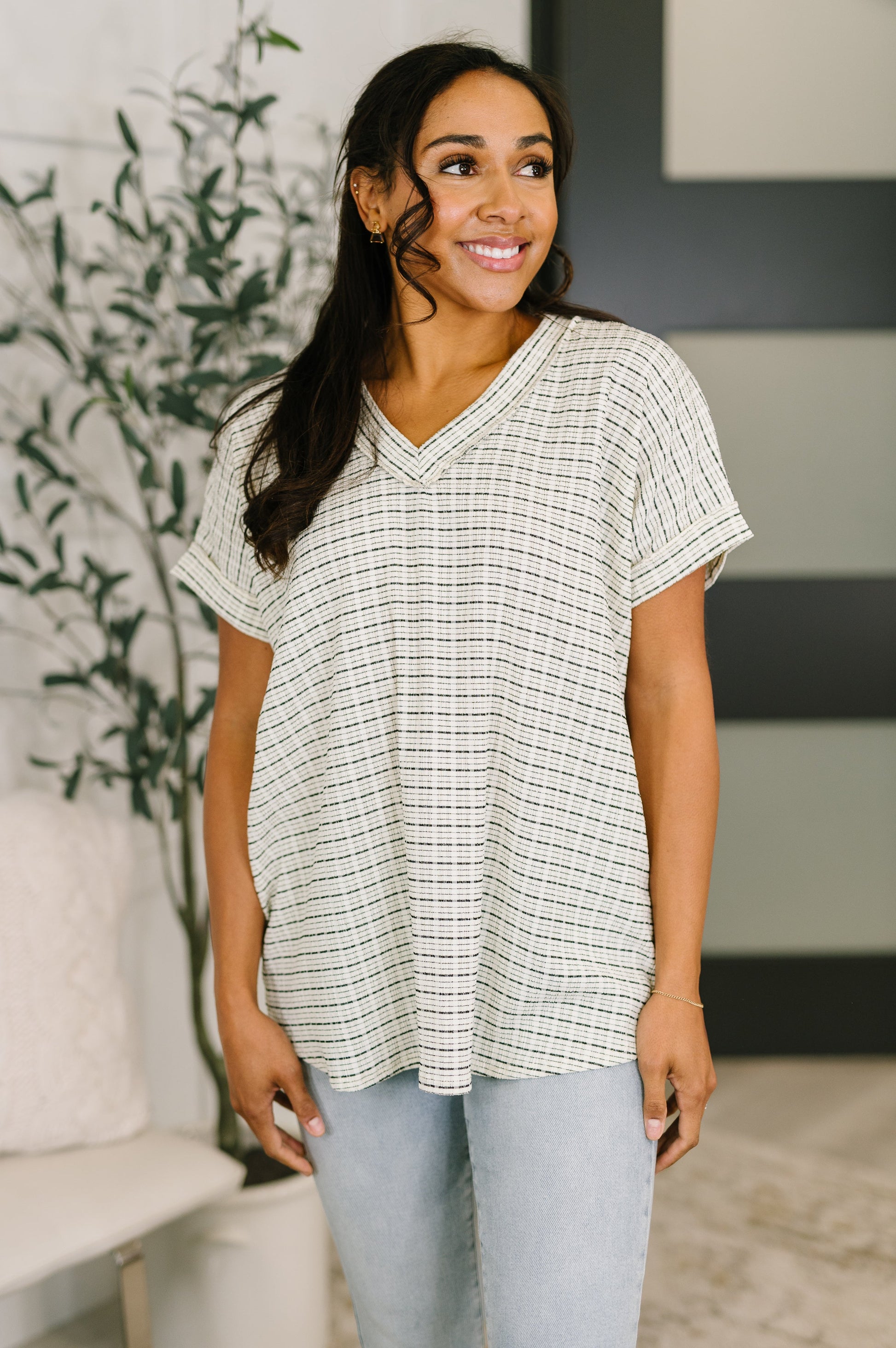 Woman wearing a checkered blouse in a home setting