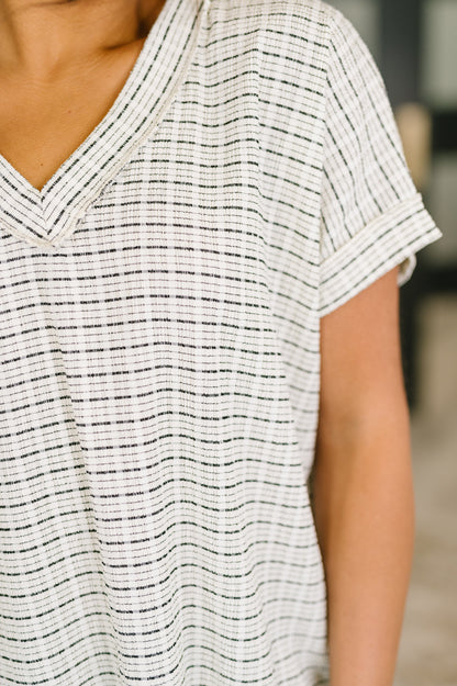 Close-up of a person wearing a black and white striped shirt.