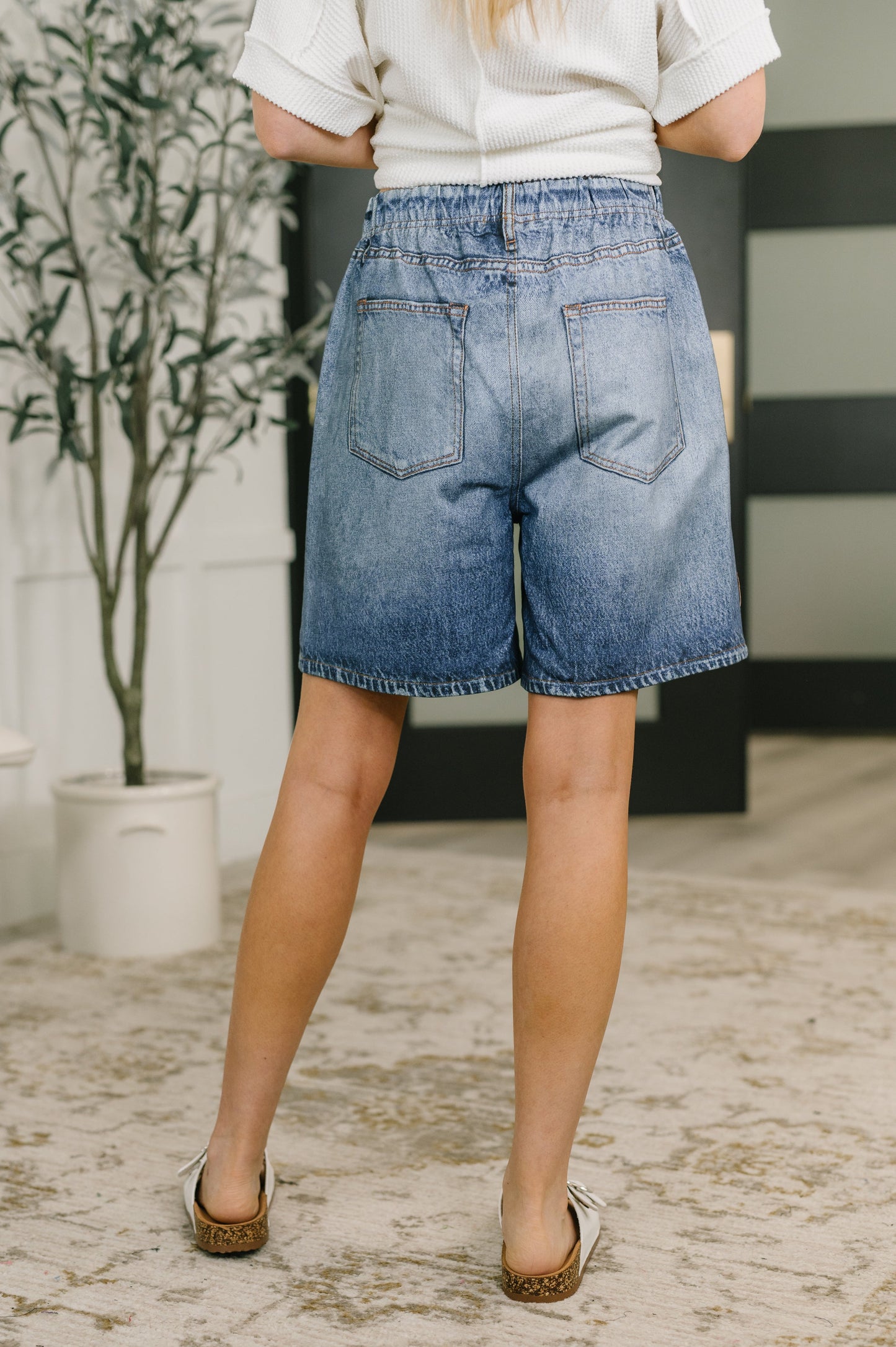 Person wearing blue denim shorts in an indoor setting