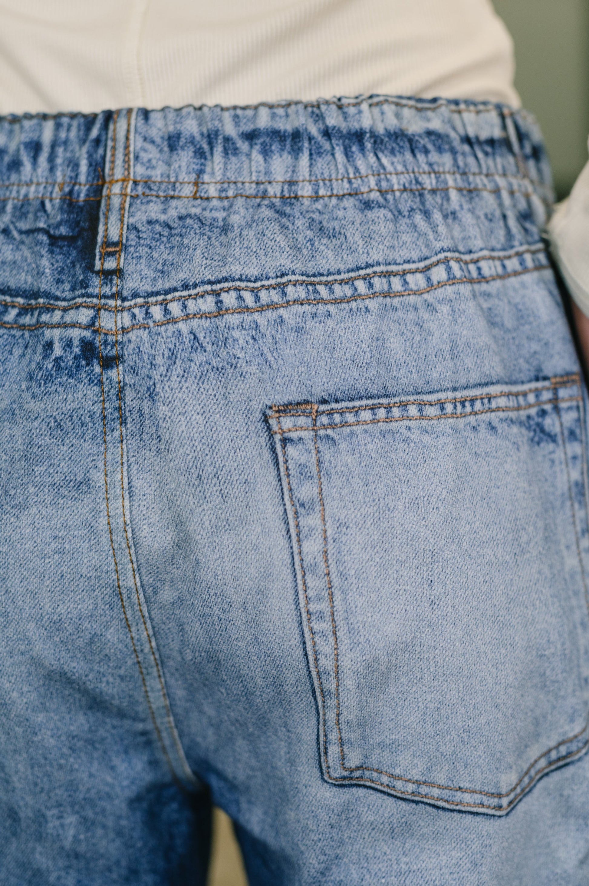 Close-up of blue denim jeans with a pocket detail.