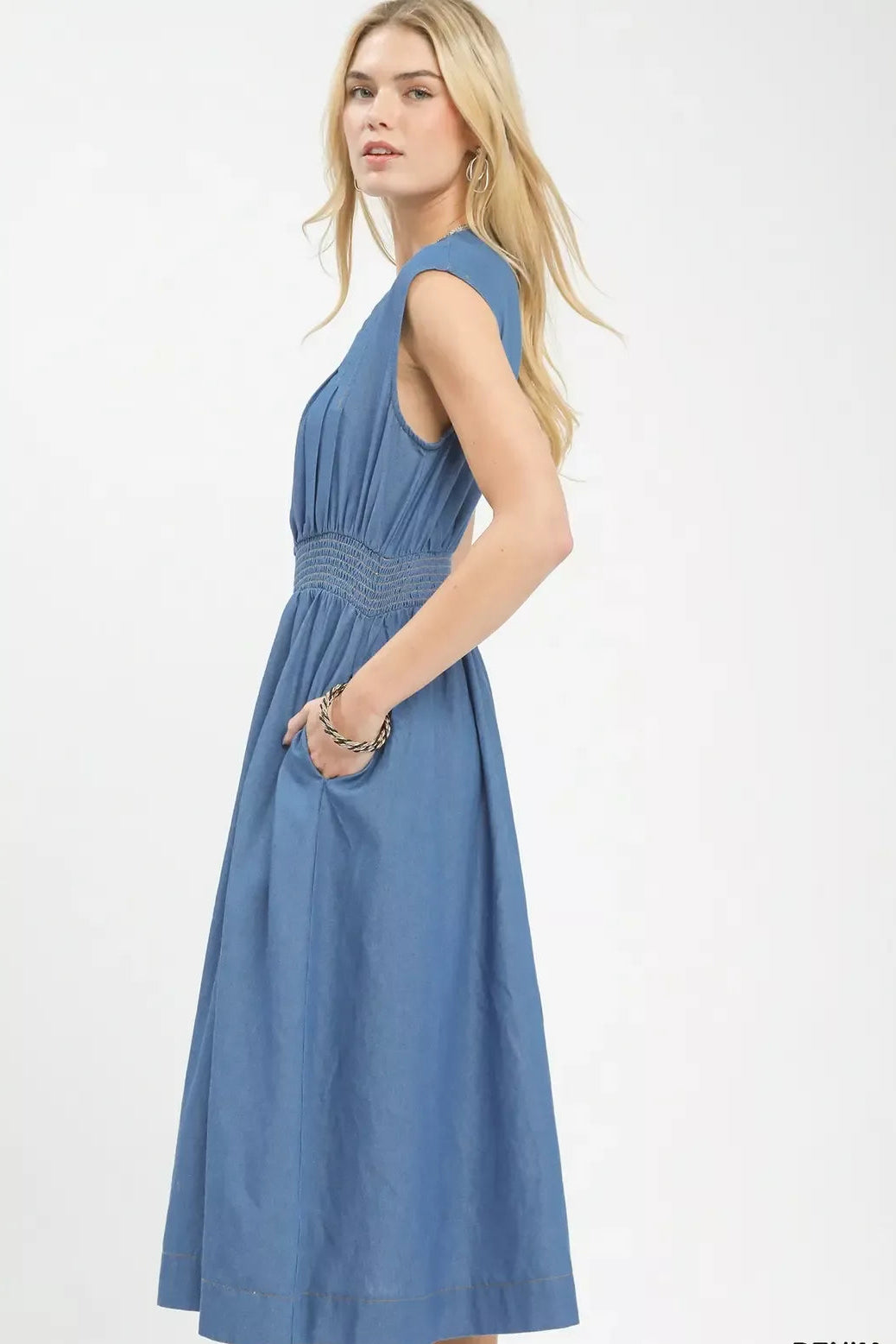 Woman wearing a blue denim dress on a white background