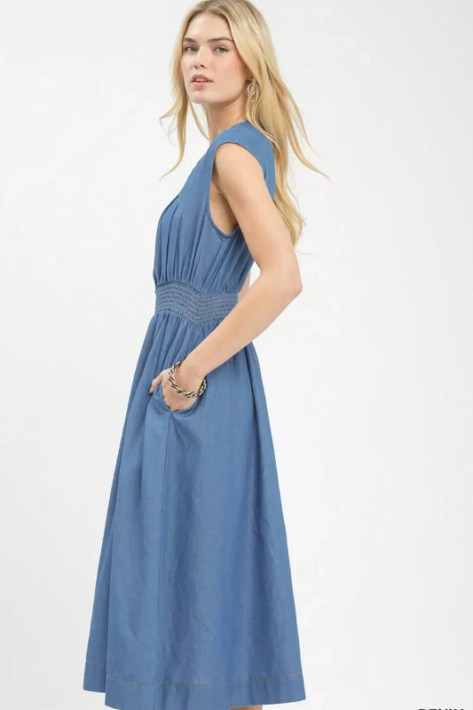 Woman wearing a blue denim dress on a white background