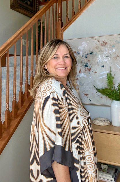 Woman standing in a home setting with a sideview of dress. 