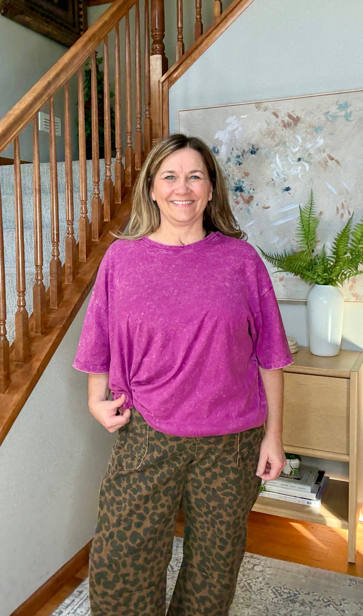 woman wearing an oversized purple short sleeve top with animal print jeans