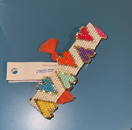 Colorful beaded bracelet with tassels on a blue surface