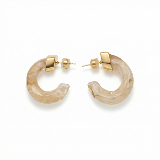 Pair of gold hoop earrings with beige stone-like material on a white background