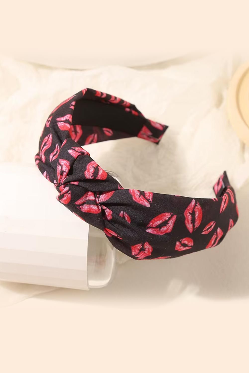 Black headband with pink lip print on a white background