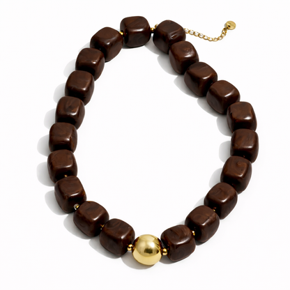Brown beaded necklace with a gold accent on a white background