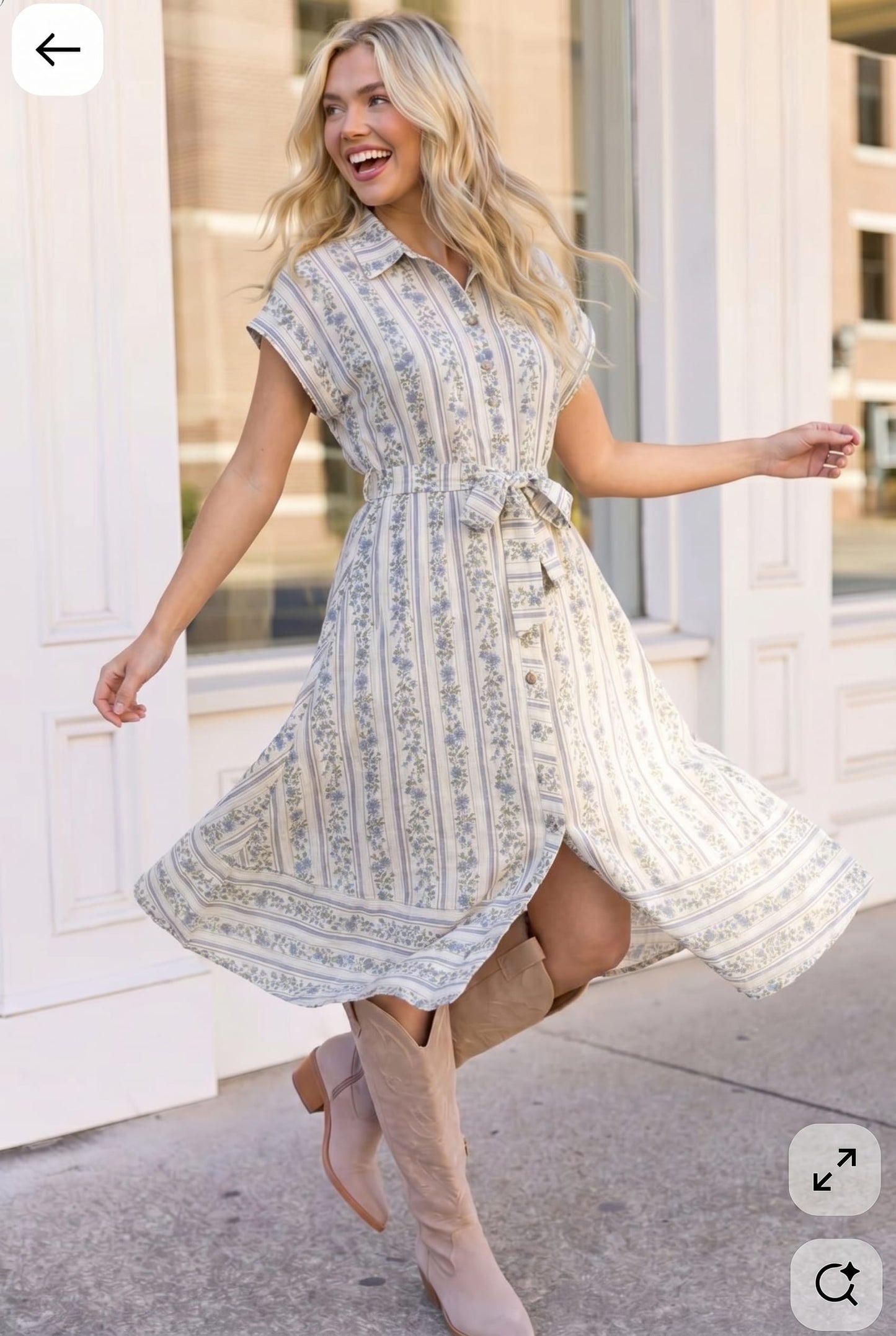 Woman in a patterned dress standing outdoors with a building in the background