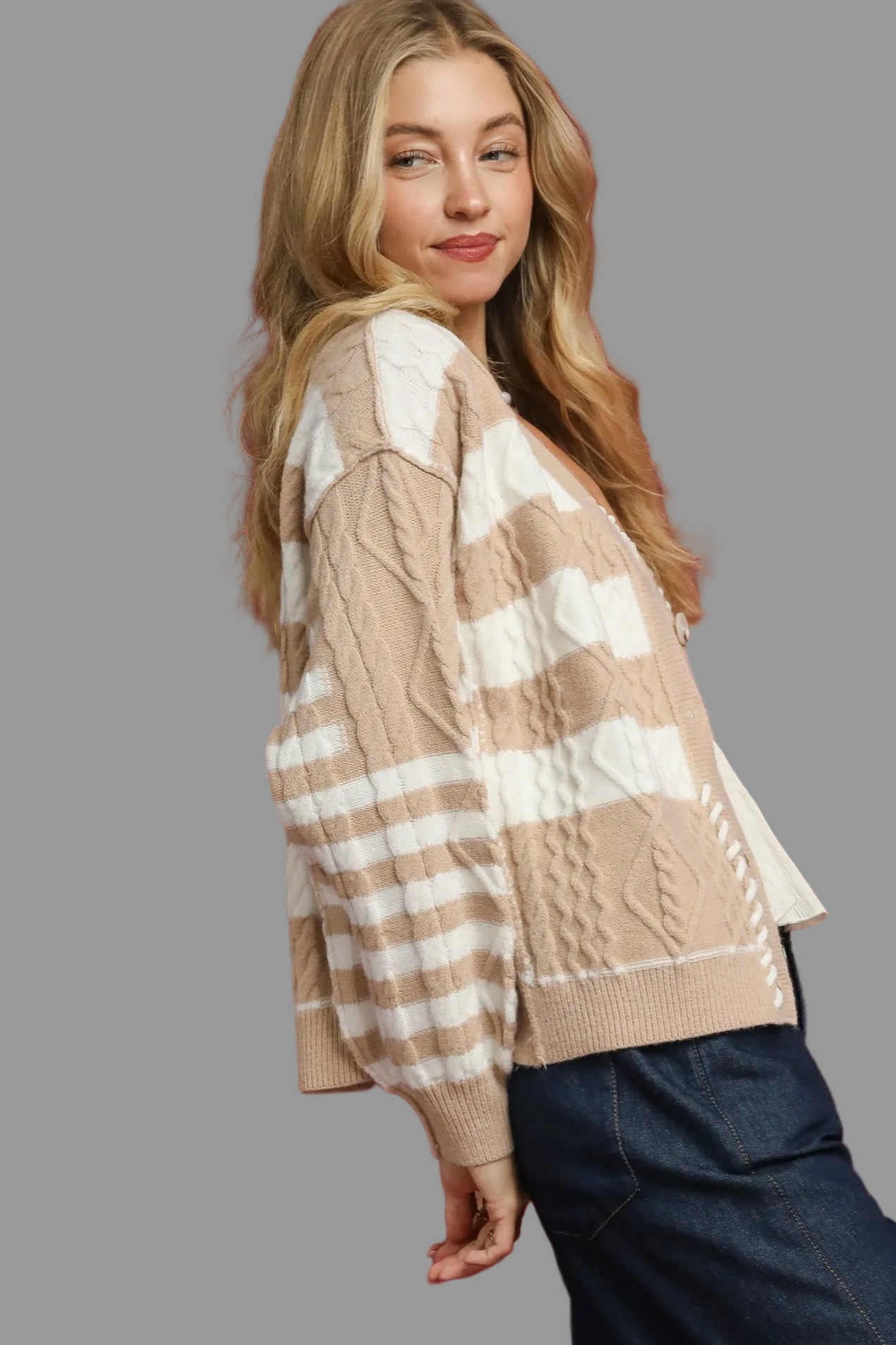 Woman wearing a beige and white striped  cardigan sweater 