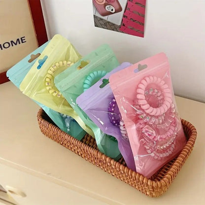 Colorful hair ties in clear packaging on a wicker basket with a blurred background
