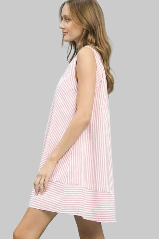 Woman wearing a pink and white striped dress against a light blue background