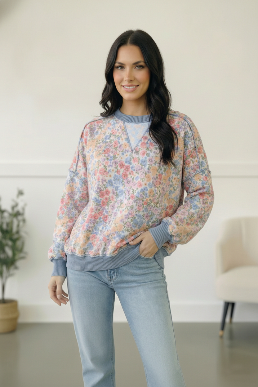 Woman wearing a floral blouse and light blue jeans indoors.