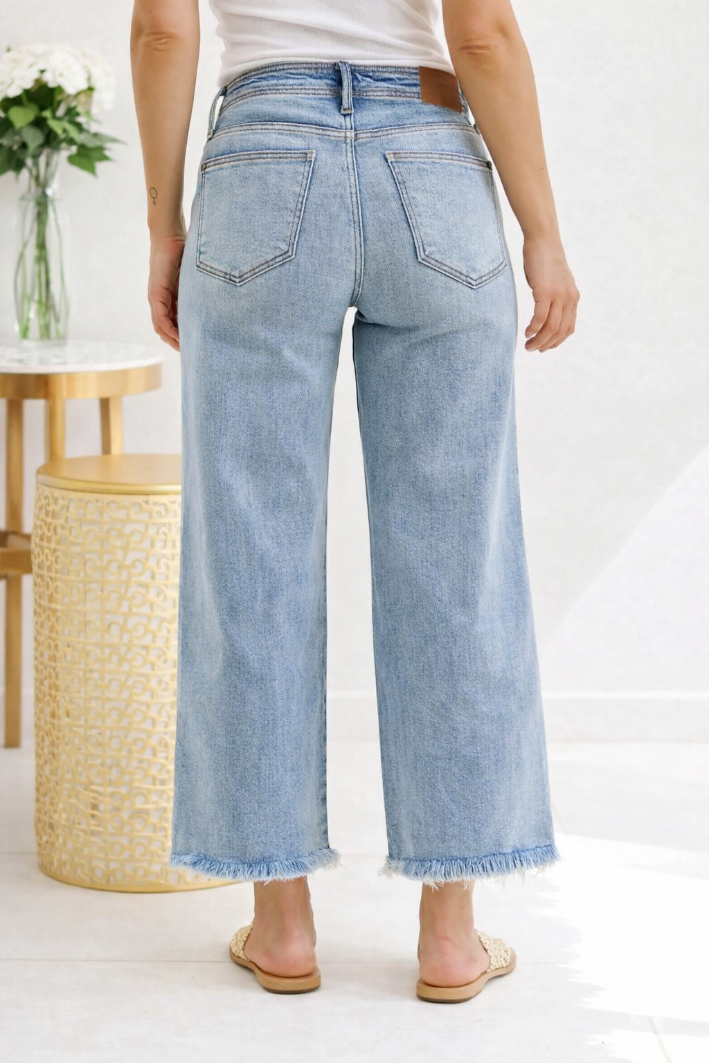 Light blue jeans worn by a person in a minimal indoor setting