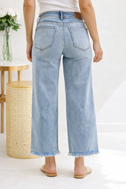 Light blue jeans worn by a person in a minimal indoor setting