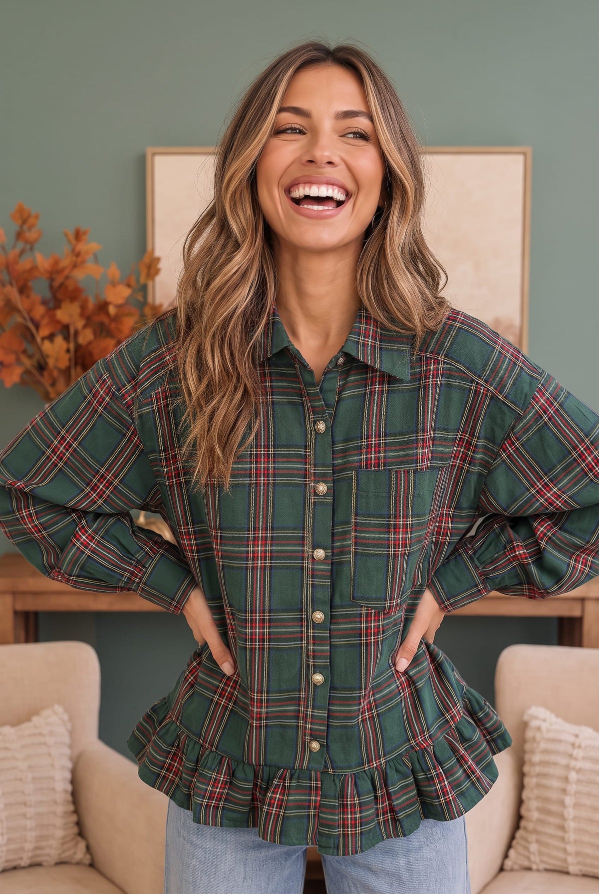 A woman wearing a green plaid button-up shirt with balloon sleeves and a ruffled peplum hem, paired with light blue jeans, standing in a cozy living room setting.