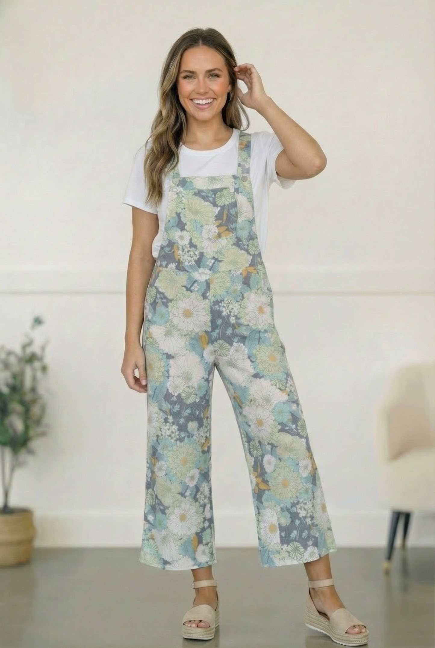 Woman wearing floral overalls with a white background