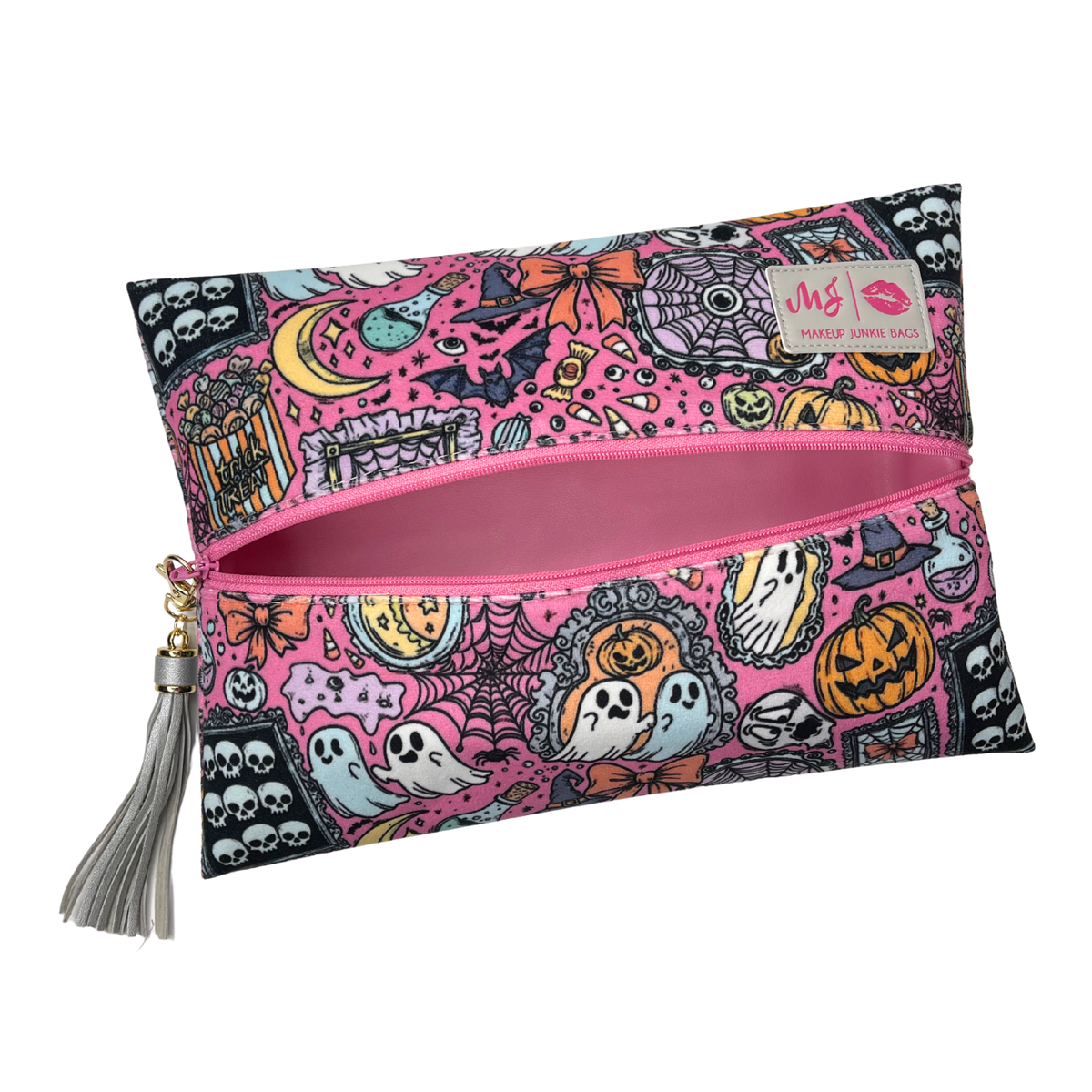 A rectangular zippered pouch with a pink and black Halloween-themed pattern featuring ghosts, pumpkins, skulls, and spiders. The pouch has a silver tassel zipper pull and a small brand label on the upper right.
