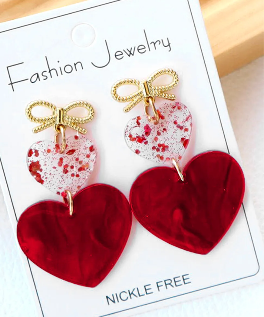 Heart-shaped earrings with gold bows on a 'Fashion Jewelry' card.