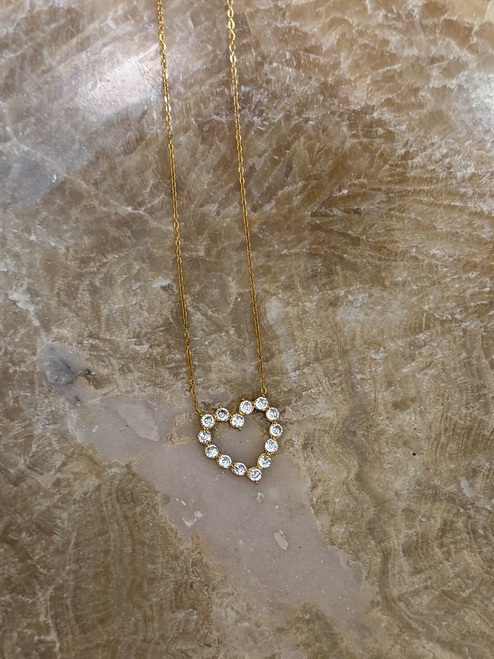 Heart-shaped diamond necklace on a marble surface