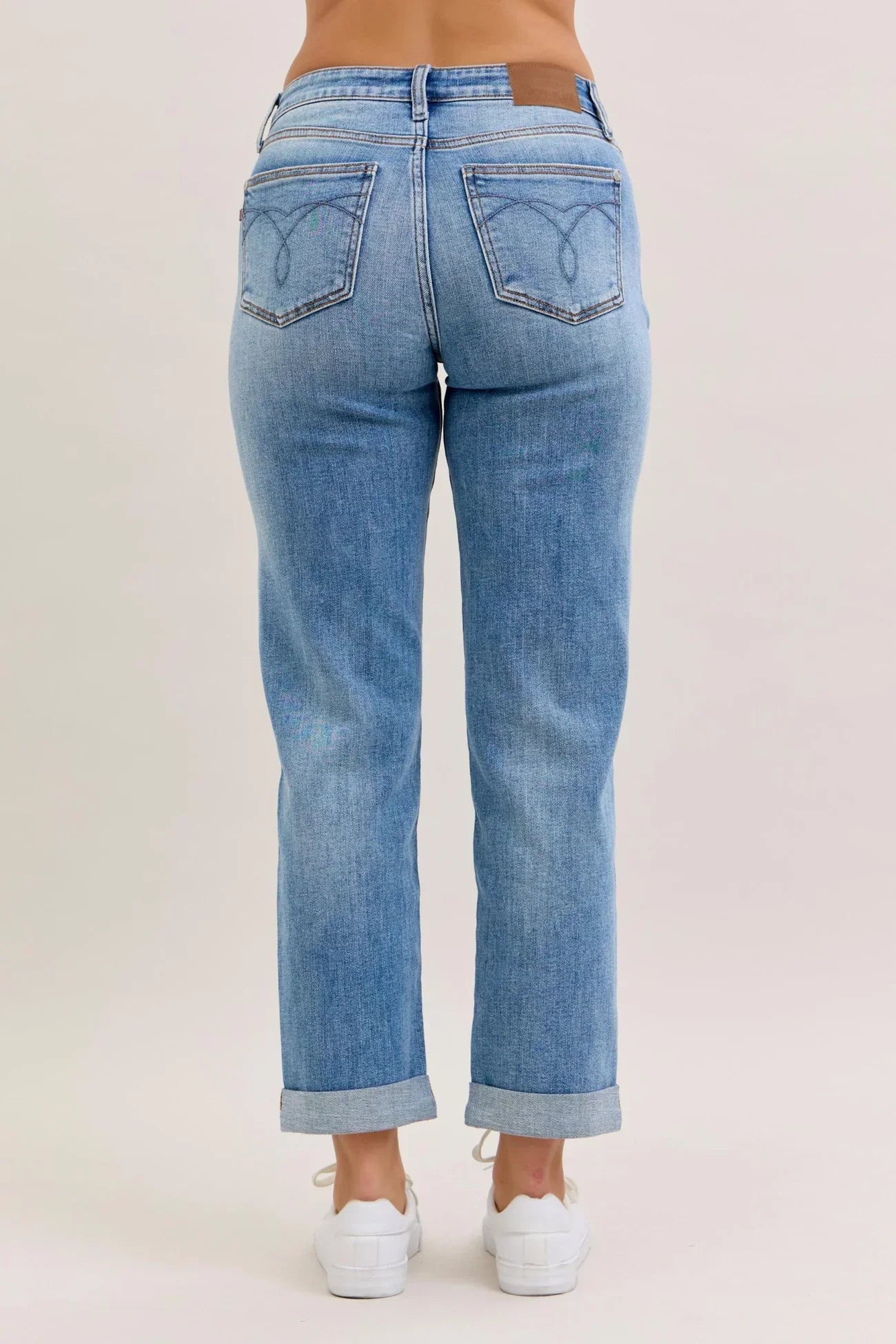 Light blue jeans worn by a person on a plain background