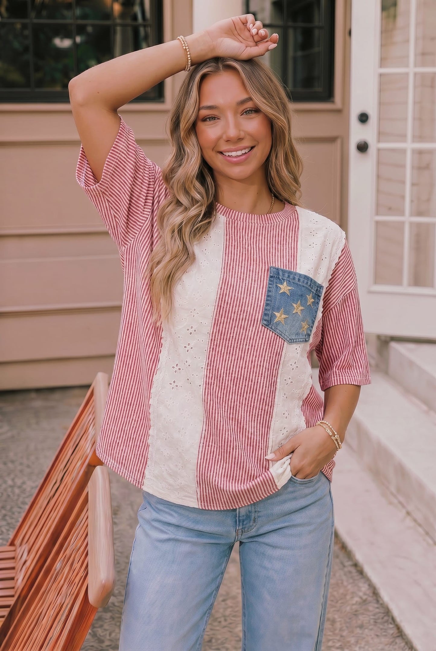 Woman wearing a red and white checkered shirt with a blue pocket design, standing outdoors.