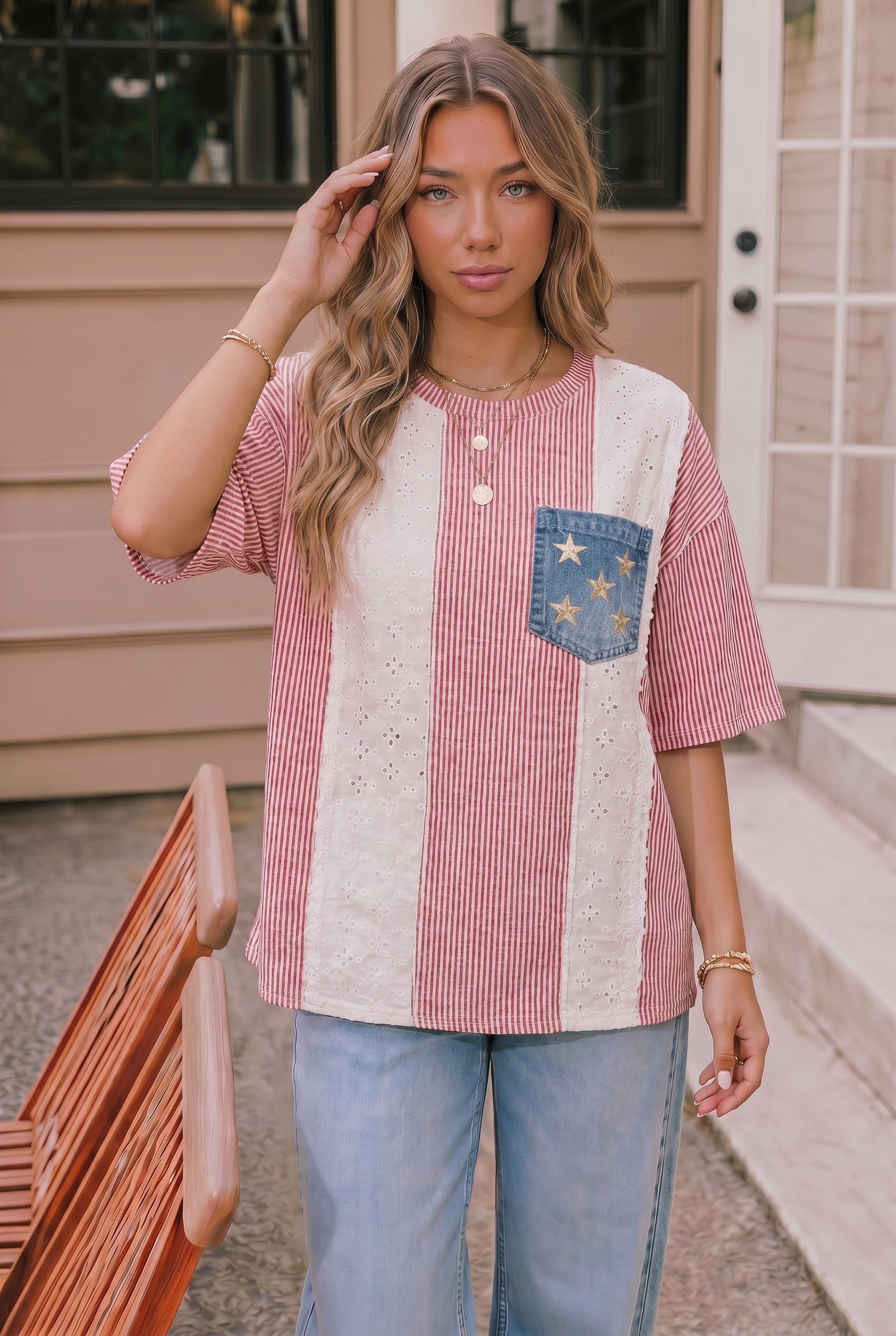 Woman wearing a red, white, and blue striped shirt with a pocket design outdoors.