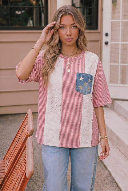 Woman wearing a red, white, and blue striped shirt with a pocket design outdoors.
