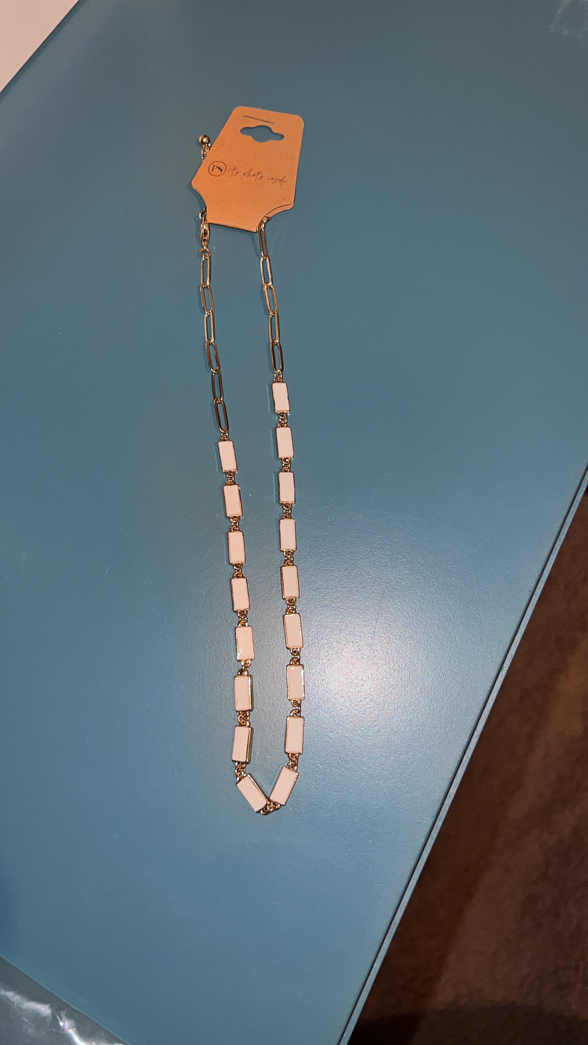 Necklace with a pink and silver design on a blue surface