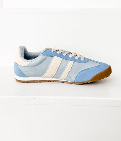 Light blue sneaker with white stripes on a white background