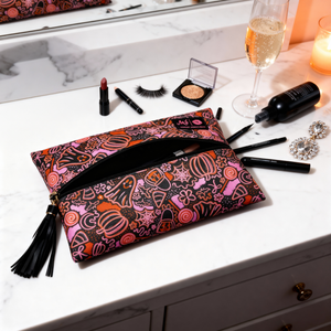 Colorful makeup pouch on a vanity with various makeup items around
