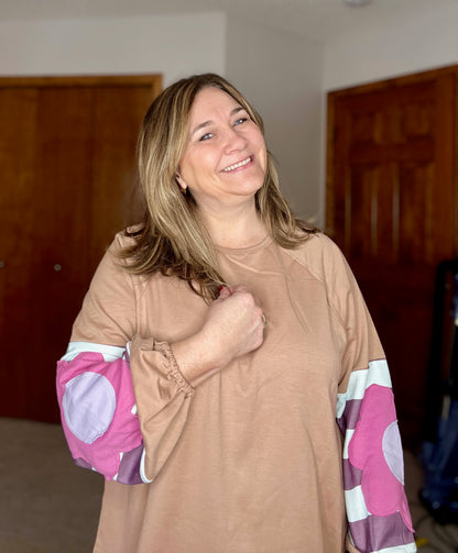Woman wearing a boho floral top with colorful sleeves in an indoor setting