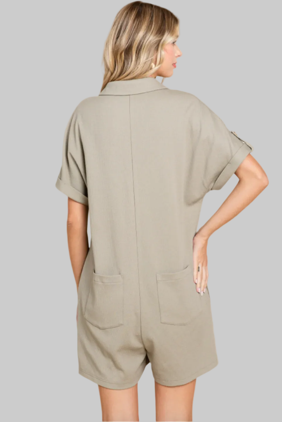 Woman wearing a beige romper on a white background