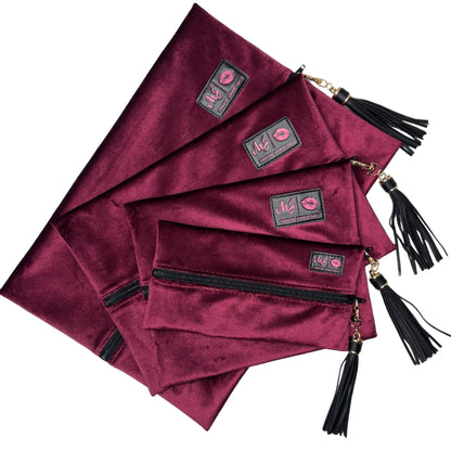 Set of burgundy pouches with tassels and visible brand logo on a white background