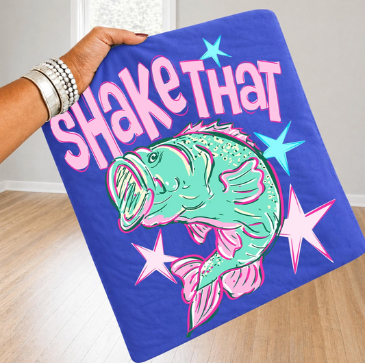 Person holding a colorful towel with a fish design and text on a wooden floor.