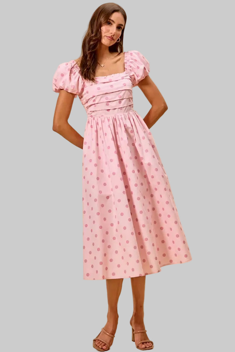 Woman wearing a pink dress with puff sleeves on a beige background